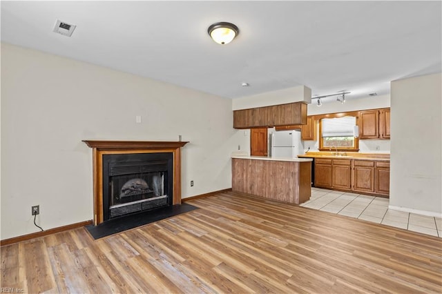 128 Glen Echo Dr, Norfolk, VA 23505 - kitchen with freestanding refrigerator, a peninsula, light countertops, and light wood-style floors