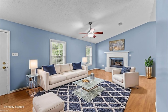 1801 Cougar Ct, Virginia Beach, VA 23456 - living room featuring a ceiling fan, a textured ceiling, wood finished floors, a glass covered fireplace, and lofted ceiling