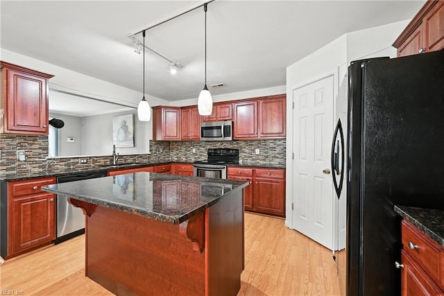 742 Milby Dr, Chesapeake, VA 23325 - kitchen with appliances with stainless steel finishes, light wood-type flooring, a center island, and decorative backsplash