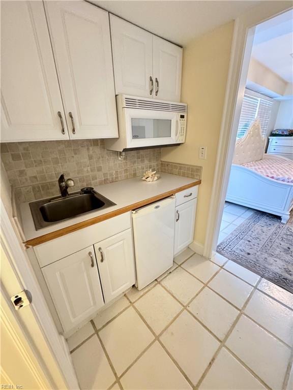 508 Virginia Dare Dr, Virginia Beach, VA 23451 - kitchen with white appliances, white cabinets, tasteful backsplash, light countertops, and light tile patterned floors