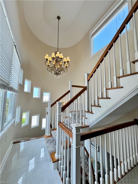 508 Virginia Dare Dr, Virginia Beach, VA 23451 - staircase featuring a towering ceiling, plenty of natural light, a chandelier, and marble finish flooring