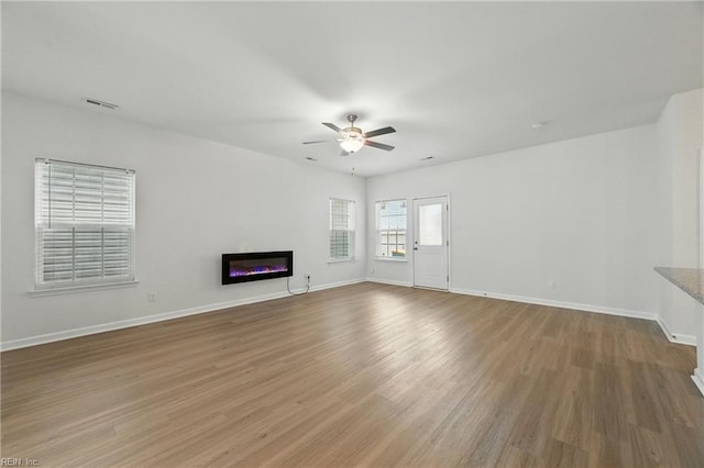 1506 Waltham Ln, Newport News, VA 23608 - unfurnished living room featuring a glass covered fireplace, ceiling fan, and wood finished floors