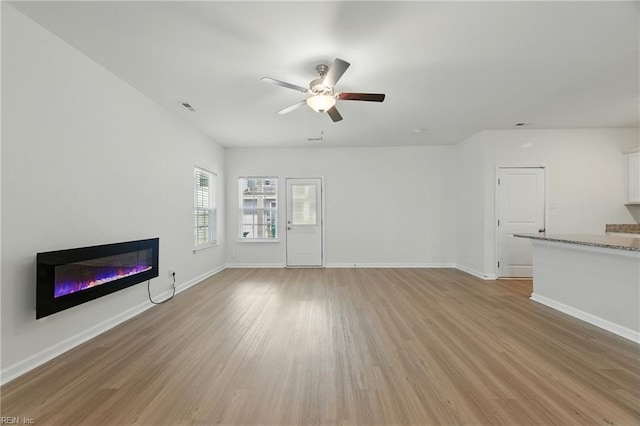 1506 Waltham Ln, Newport News, VA 23608 - unfurnished living room with a ceiling fan, light wood finished floors, and a glass covered fireplace