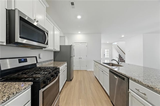 1506 Waltham Ln, Newport News, VA 23608 - kitchen featuring appliances with stainless steel finishes, light wood finished floors, white cabinets, light stone countertops, and recessed lighting