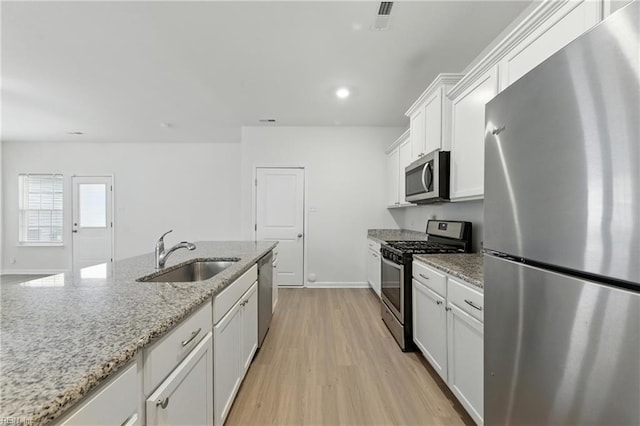 1506 Waltham Ln, Newport News, VA 23608 - kitchen featuring appliances with stainless steel finishes, light wood-style flooring, white cabinets, light stone counters, and recessed lighting