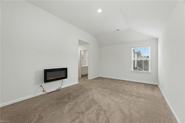 1506 Waltham Ln, Newport News, VA 23608 - unfurnished living room featuring carpet floors, lofted ceiling, a glass covered fireplace, and recessed lighting