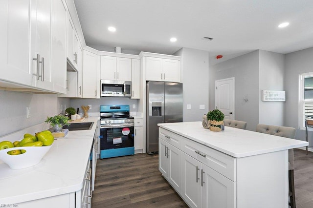 31 Bank St, Windsor, VA 23487 - kitchen featuring stainless steel appliances, dark wood-style flooring, white cabinetry, a breakfast bar area, and recessed lighting
