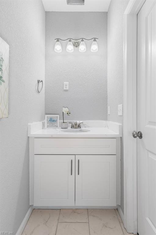 31 Bank St, Windsor, VA 23487 - bathroom with marble look tile flooring, vanity, and a textured wall