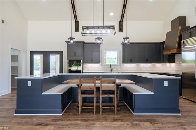 18052 Foxfire Trl, Windsor, VA 23487 - kitchen featuring stainless steel appliances, a towering ceiling, a large island, decorative backsplash, and light countertops