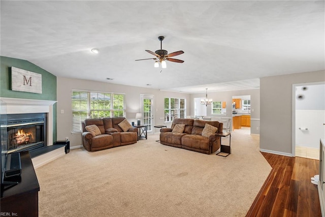 15110 Ashby Way, Carrollton, VA 23314 - carpeted living area with ceiling fan, a glass covered fireplace, a chandelier, and wood finished floors