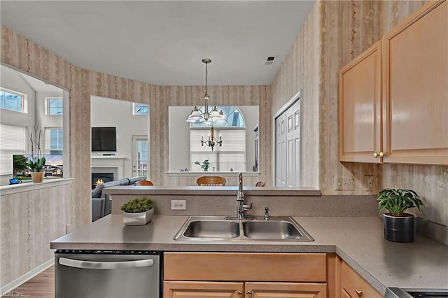 1010 Legends Way, Suffolk, VA 23435 - kitchen featuring stainless steel dishwasher, open floor plan, light brown cabinets, a lit fireplace, and wallpapered walls