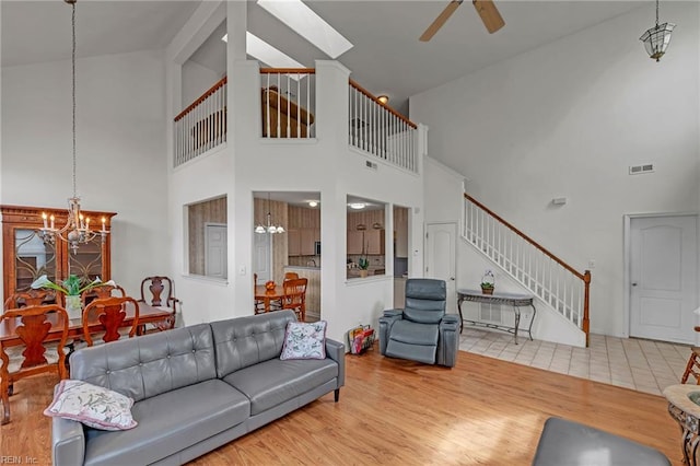 1010 Legends Way, Suffolk, VA 23435 - living area featuring high vaulted ceiling, stairway, a chandelier, a ceiling fan, and wood finished floors