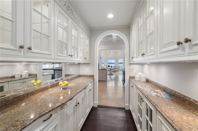 1845 N Alanton Dr, Virginia Beach, VA 23454 - kitchen with white cabinets, arched walkways, dark wood finished floors, light stone countertops, and glass insert cabinets
