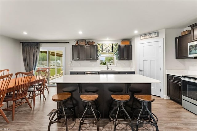6957 Healy Ave, Gloucester, VA 23061 - kitchen featuring stainless steel appliances, light countertops, a breakfast bar area, light wood finished floors, and recessed lighting
