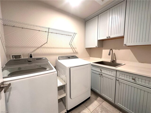 6957 Healy Ave, Gloucester, VA 23061 - laundry area featuring separate washer and dryer, cabinet space, and light tile patterned floors