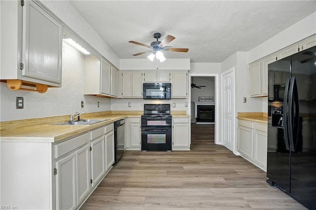 2116 Bloomsbury Ln, Virginia Beach, VA 23454 - kitchen featuring black appliances, a ceiling fan, light countertops, light wood-style flooring, and a textured wall