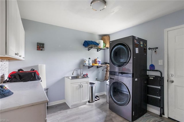 7600 Bridgette Ln, Norfolk, VA 23518 - washroom with estacked washer and dryer, cabinet space, and light wood-style floors