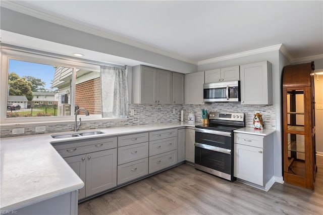 7600 Bridgette Ln, Norfolk, VA 23518 - kitchen featuring stainless steel appliances, gray cabinets, crown molding, and light wood-style flooring