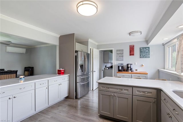 7600 Bridgette Ln, Norfolk, VA 23518 - kitchen featuring stainless steel fridge, a wall mounted AC, light countertops, gray cabinetry, and a peninsula
