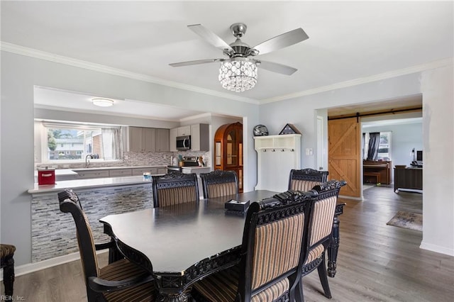 7600 Bridgette Ln, Norfolk, VA 23518 - dining area featuring a barn door, light wood-type flooring, a ceiling fan, and ornamental molding