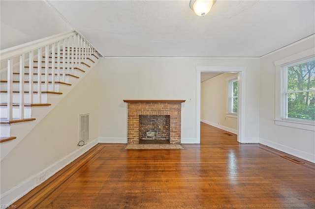 5004 Powhatan Ave, Norfolk, VA 23508 - unfurnished living room featuring wood finished floors, stairs, and a brick fireplace