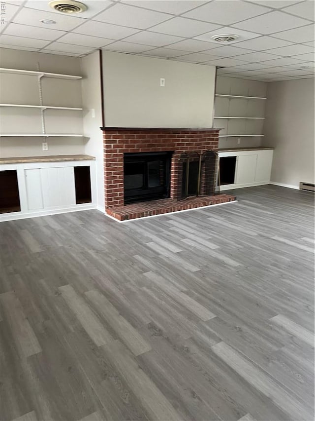 2453 Malden Ave, Norfolk, VA 23518 - unfurnished living room with a brick fireplace, wood finished floors, built in shelves, and a drop ceiling