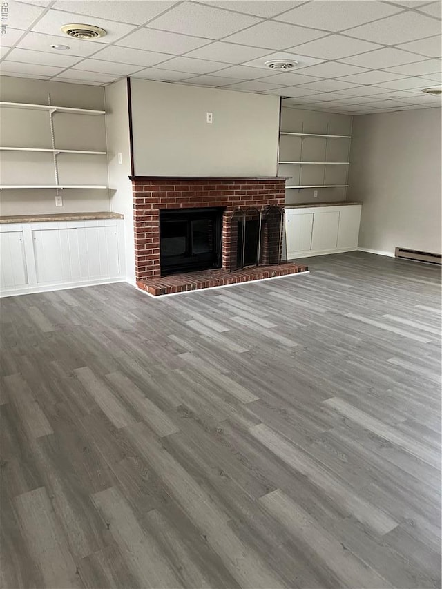 2453 Malden Ave, Norfolk, VA 23518 - unfurnished living room featuring wood finished floors, baseboard heating, a fireplace, and a drop ceiling