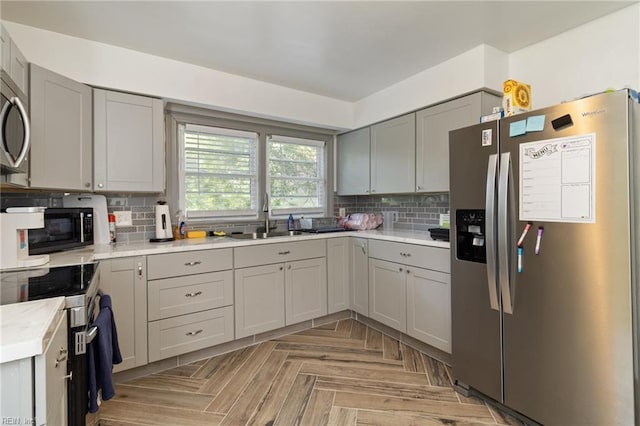 2220 Rodgers St, Chesapeake, VA 23324 - kitchen featuring appliances with stainless steel finishes, gray cabinetry, tasteful backsplash, and light countertops