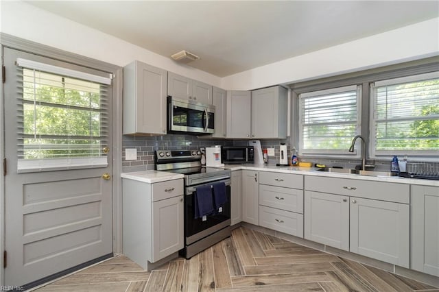 2220 Rodgers St, Chesapeake, VA 23324 - kitchen featuring stainless steel appliances, gray cabinetry, light countertops, and backsplash