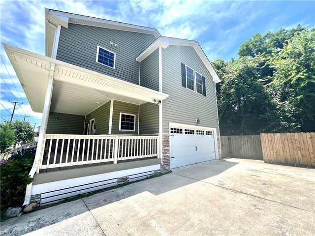 3109 Pleasant Ave, Norfolk, VA 23518 - view of front of home featuring a porch, concrete driveway, an attached garage, and stone siding