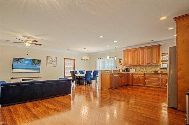 3109 Pleasant Ave, Norfolk, VA 23518 - kitchen with a peninsula, stainless steel appliances, open floor plan, brown cabinets, and ornamental molding