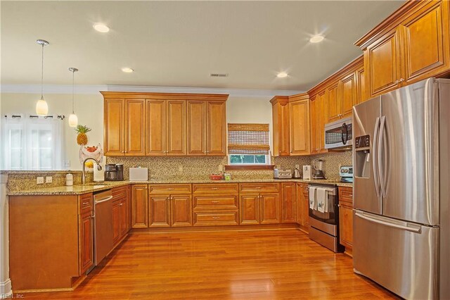 3109 Pleasant Ave, Norfolk, VA 23518 - kitchen with stainless steel appliances, a peninsula, brown cabinets, light stone countertops, and light wood-style floors