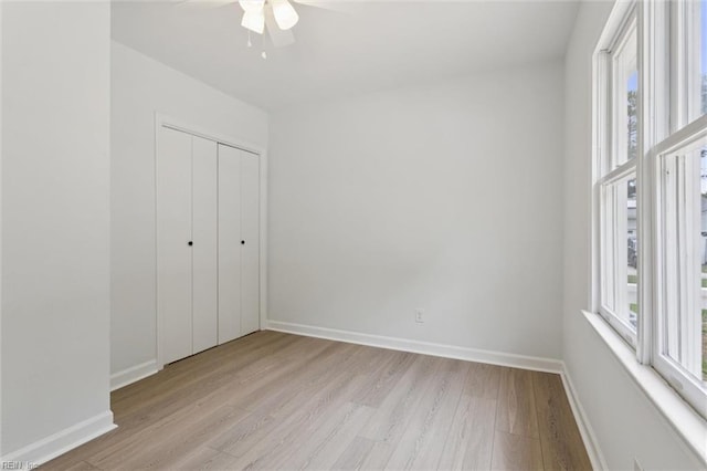 13067 Poor House Rd, Windsor, VA 23487 - unfurnished bedroom with light wood finished floors, a closet, and a ceiling fan