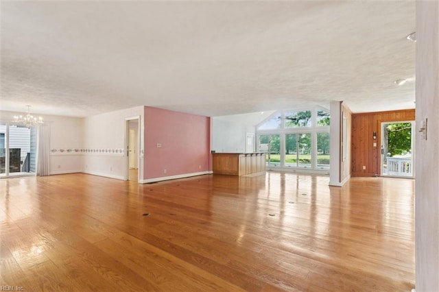133 Randolphs Grn, Williamsburg, VA 23185 - unfurnished living room with a chandelier, wood finished floors, a textured ceiling, and wood walls