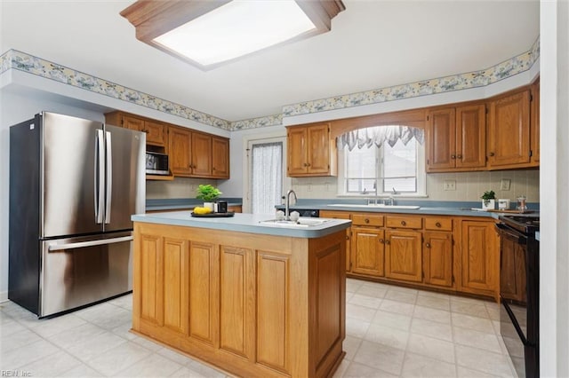 133 Randolphs Grn, Williamsburg, VA 23185 - kitchen with stainless steel appliances, a center island with sink, brown cabinets, and tasteful backsplash