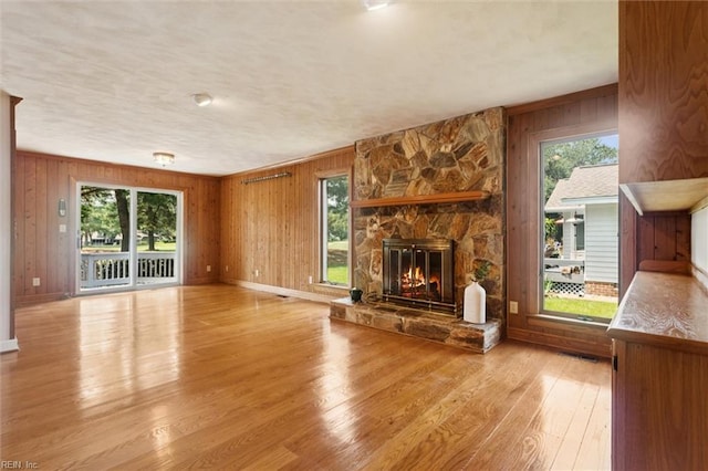 133 Randolphs Grn, Williamsburg, VA 23185 - unfurnished living room with wood walls, a fireplace, and light wood-type flooring