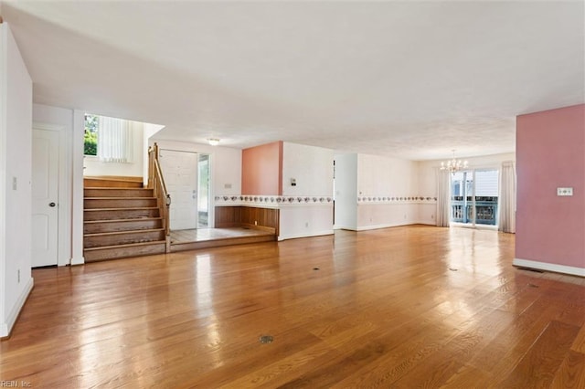 133 Randolphs Grn, Williamsburg, VA 23185 - unfurnished living room featuring a chandelier, wood finished floors, and healthy amount of natural light