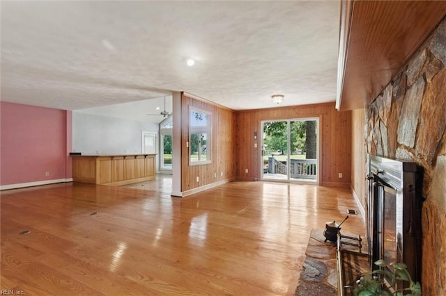 133 Randolphs Grn, Williamsburg, VA 23185 - unfurnished living room featuring light wood finished floors, a fireplace, and wood walls