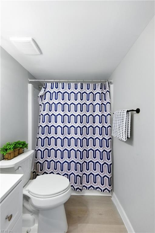 628 Crows Nest Ct Unit 101, Virginia Beach, VA 23462 - full bathroom featuring curtained shower, vanity, and wood finished floors
