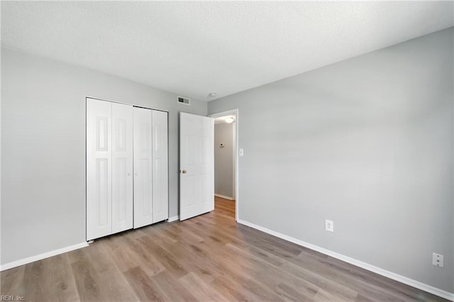 628 Crows Nest Ct Unit 101, Virginia Beach, VA 23462 - unfurnished bedroom with wood finished floors, a closet, and a textured ceiling