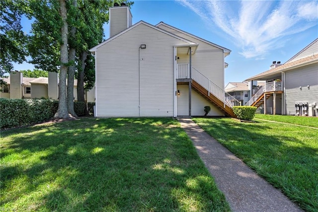 628 Crows Nest Ct Unit 101, Virginia Beach, VA 23462 - back of house featuring a yard, stairway, and a chimney