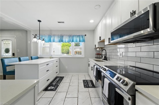 22 Greenwell Dr, Hampton, VA 23666 - kitchen featuring stainless steel appliances, light marble finish floors, light countertops, white cabinetry, and decorative backsplash