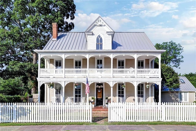 826 Lee St, West Point, VA 23181 - view of front of property with a porch, a balcony, a fenced front yard, and a chimney