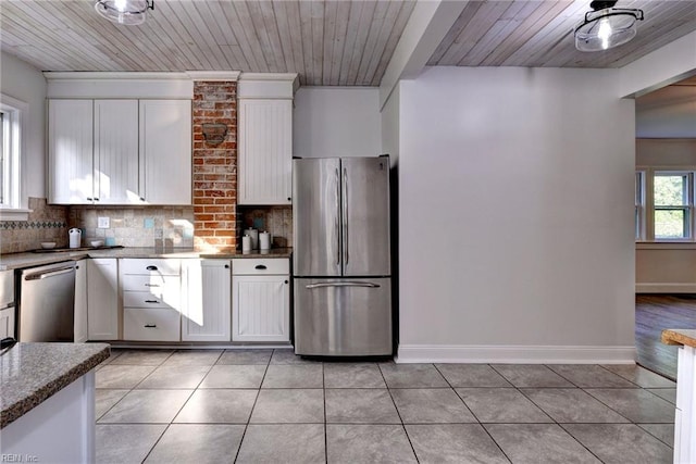 826 Lee St, West Point, VA 23181 - kitchen featuring appliances with stainless steel finishes, light tile patterned floors, backsplash, white cabinets, and wood ceiling