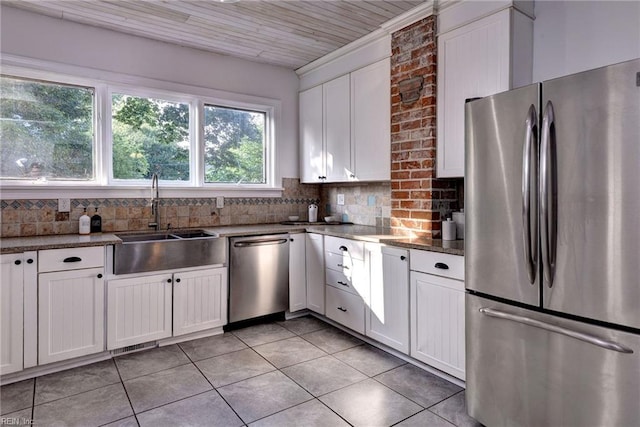 826 Lee St, West Point, VA 23181 - kitchen featuring appliances with stainless steel finishes, light tile patterned floors, white cabinets, and backsplash