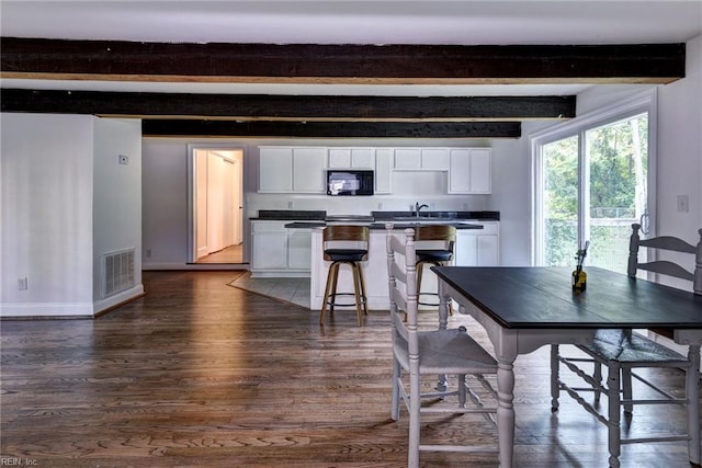 826 Lee St, West Point, VA 23181 - dining area with dark wood-type flooring and beam ceiling
