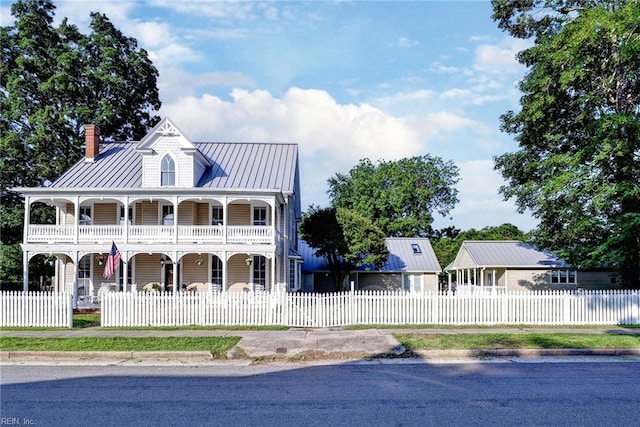 826 Lee St, West Point, VA 23181 - view of front facade with a porch, a chimney, a fenced front yard, a metal roof, and a standing seam roof