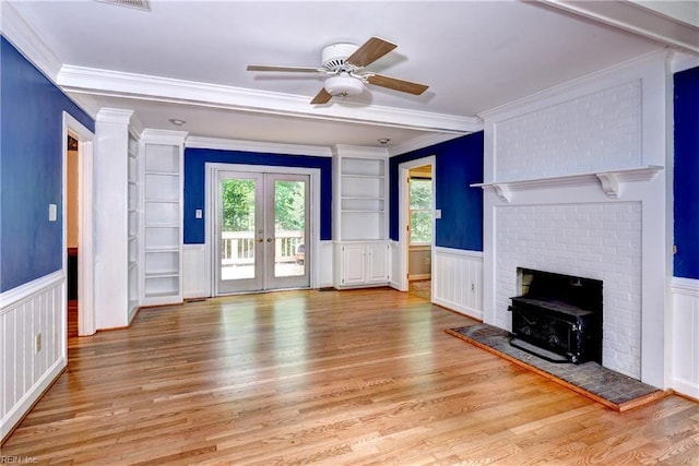 308 Royal Grant Dr, Williamsburg, VA 23185 - unfurnished living room with wood finished floors, french doors, a wood stove, ceiling fan, and a wainscoted wall