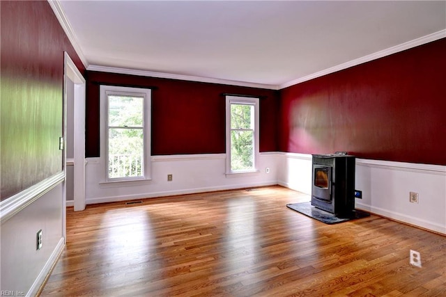 308 Royal Grant Dr, Williamsburg, VA 23185 - unfurnished room with healthy amount of natural light, wood finished floors, crown molding, and a wood stove