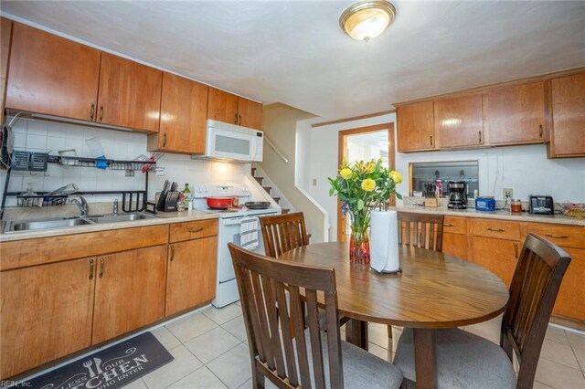 3318 Loam St, Norfolk, VA 23518 - kitchen featuring white appliances, light tile patterned floors, light countertops, tasteful backsplash, and brown cabinetry